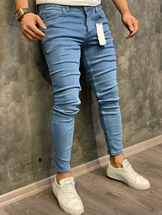 Los jeans elásticos de ajuste de hombres europeos y americanos con pequeños pies son tricolor clásicos